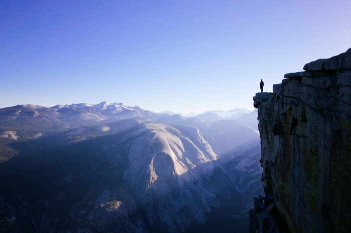 Person standing on a cliff overlooking mountains