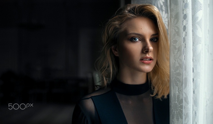 Portrait of a blonde woman by a window