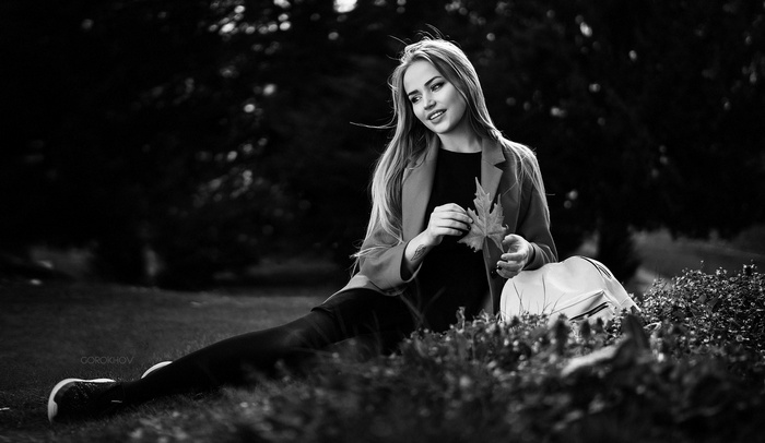 Maria Puchnina sitting in a park holding a leaf