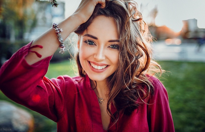 Portrait of a smiling woman with hands on head