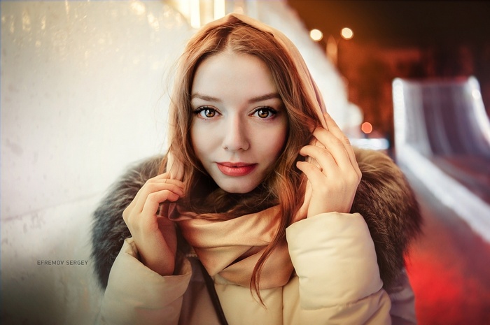 Portrait of a woman with red hair wearing a hooded jacket