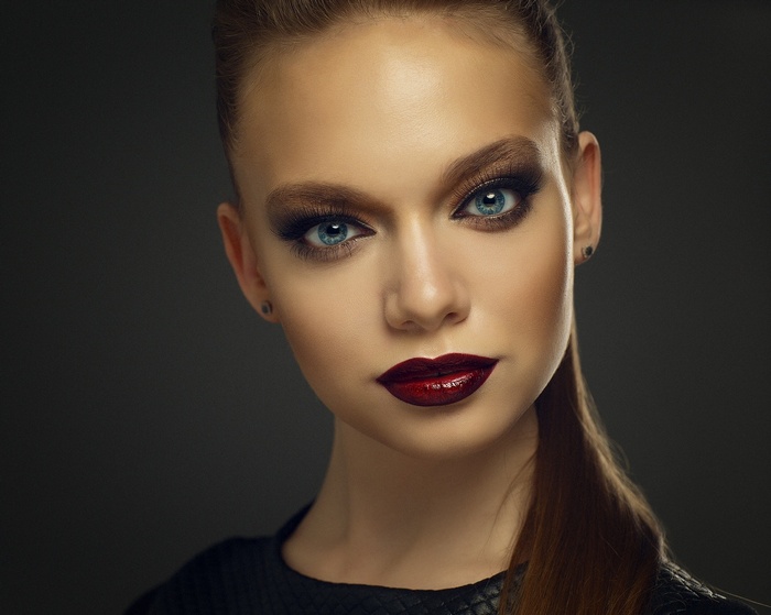 Woman with blue eyes and dark lipstick