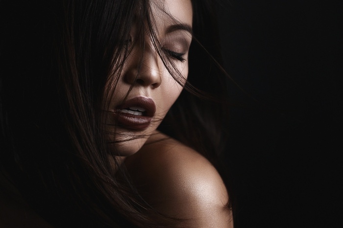 Woman with dark hair and dark lipstick