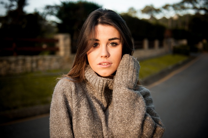 Woman in a grey sweater outdoors