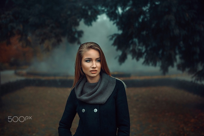 Woman in black coat and scarf in park
