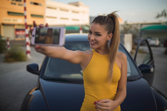 Woman taking a selfie with her car
