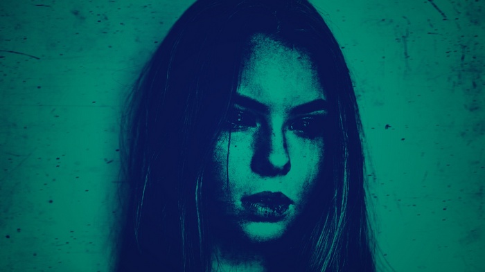 Woman with dark hair and green background