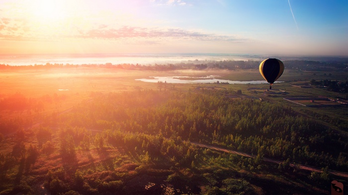 Hot air balloon over a misty landscape at sunrise