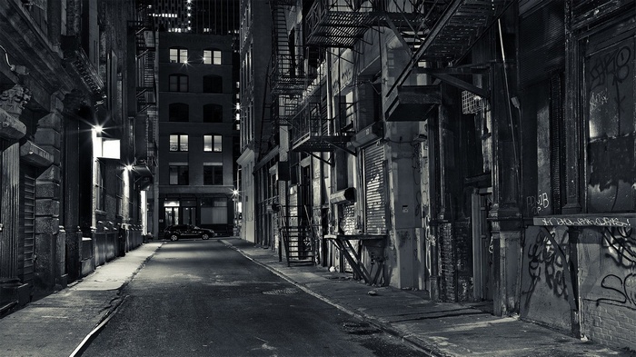 Dark city alleyway at night with graffiti