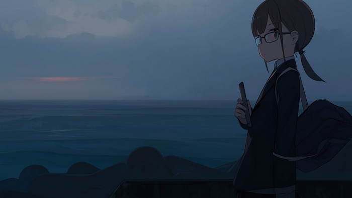 Girl with glasses looking at the sea at dusk