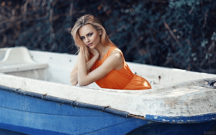 Woman in orange dress in a boat