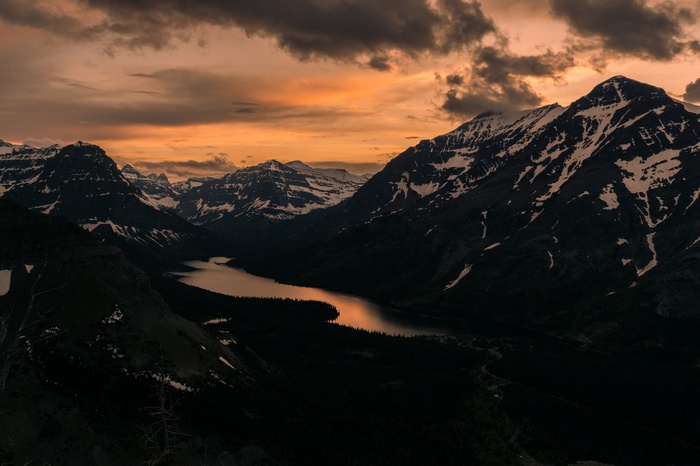 Snow-capped mountains and lake at sunset
