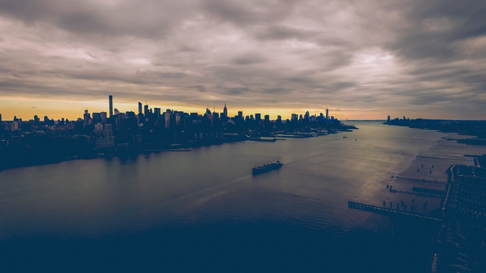 New York City skyline over the water with a ship