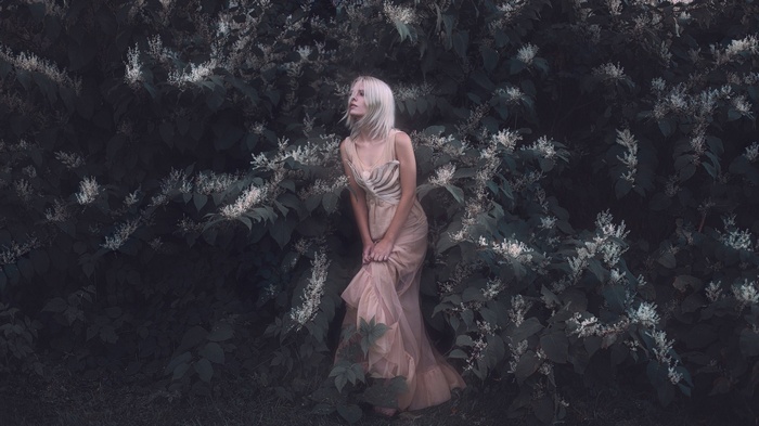 Woman in a flowing dress among white flowers