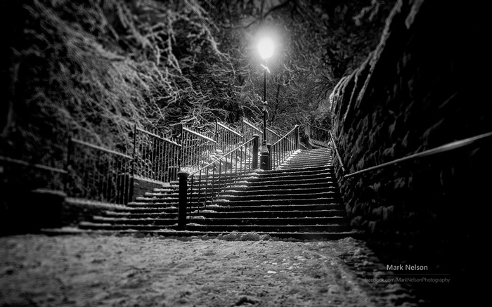 Snowy stairs at night with a street lamp