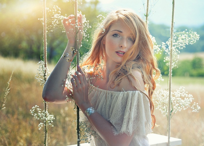 Redhead woman with blue eyes on a swing
