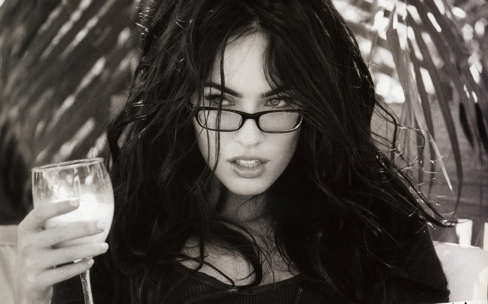 Megan Fox wearing glasses holding a drink