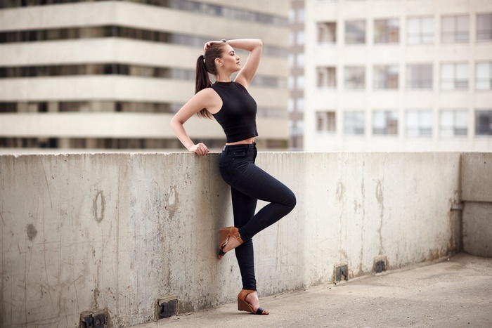 Woman with ponytail in black outfit on rooftop