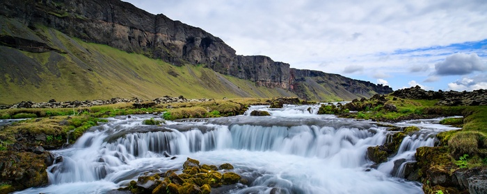Waterfall cascading down a rocky cliff face in Iceland