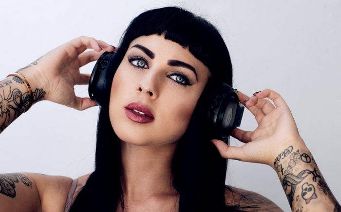 Woman with headphones and tattoos