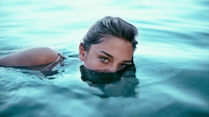 Woman emerging from blue water