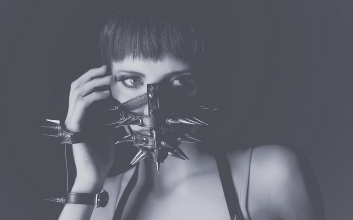 Woman wearing a spiked mask and wrist cuffs