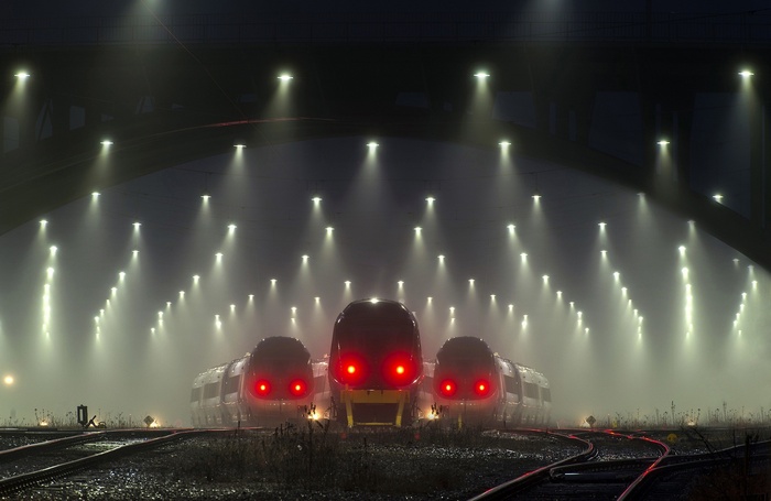 Trains with red eyes in the mist at night