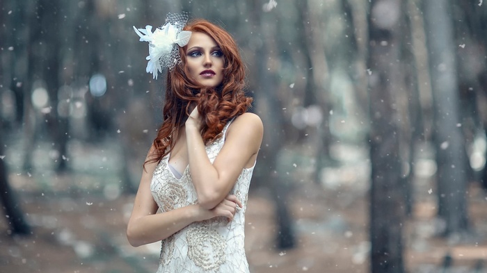 Woman with red hair and white dress in forest