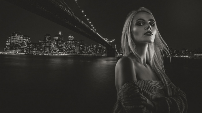 Woman posing in front of Brooklyn Bridge at night