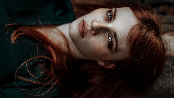 Portrait of a young woman with red hair and freckles