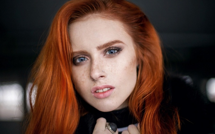 Portrait of a young woman with red hair and freckles