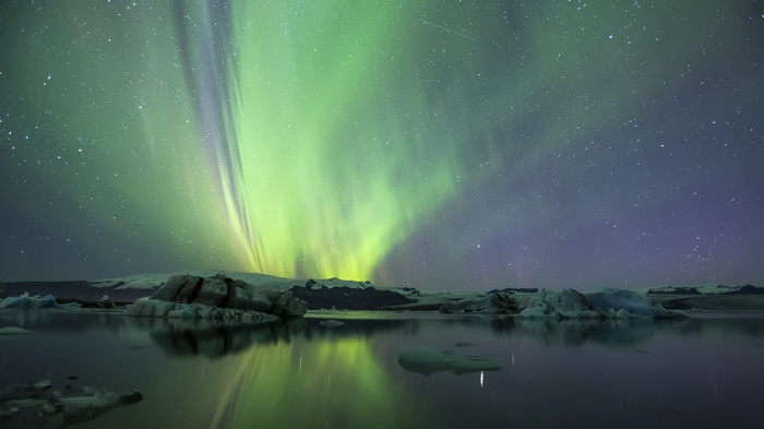 Aurora Borealis over icebergs in water