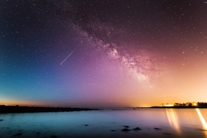 Milky Way over ocean with shooting star