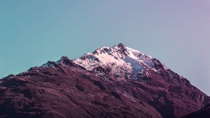Snow-capped mountain peak against a gradient sky