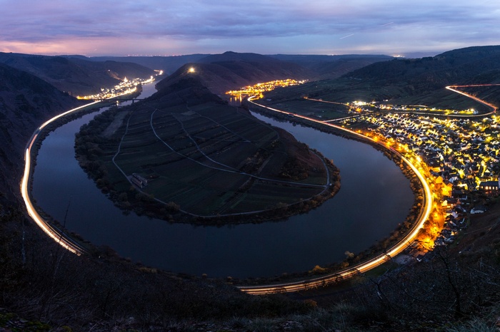 River bend with town lights and light trails at night