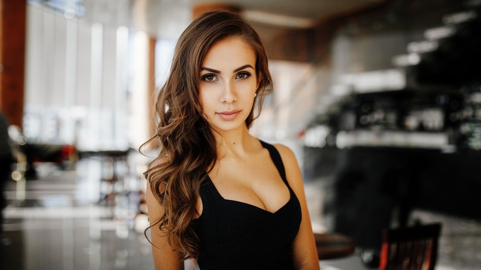 Woman in black dress with wavy hair