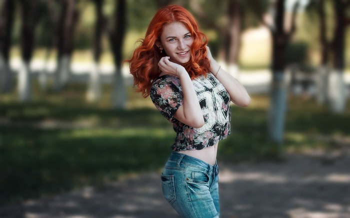 Redhead woman in jeans and floral top outdoors
