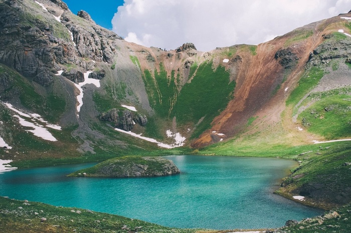 Turquoise alpine lake surrounded by mountains