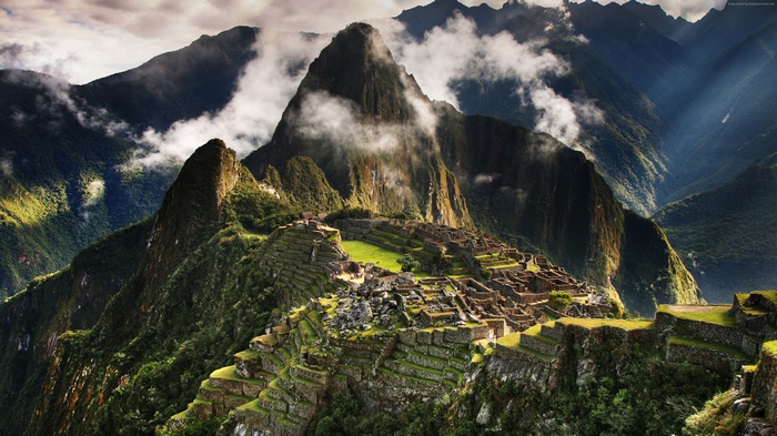 Machu Picchu ruins in the Andes mountains with clouds