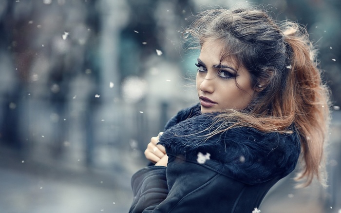 Woman in fur-lined coat in falling snow