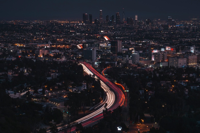 Los Angeles cityscape at night with light trails on highway
