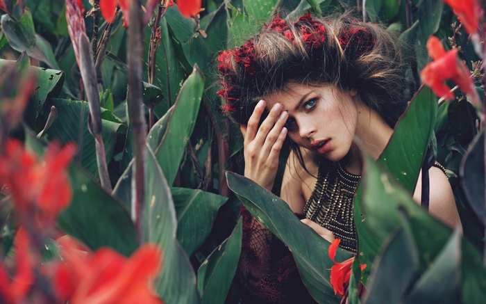 Woman with red flowers in hair and beaded top