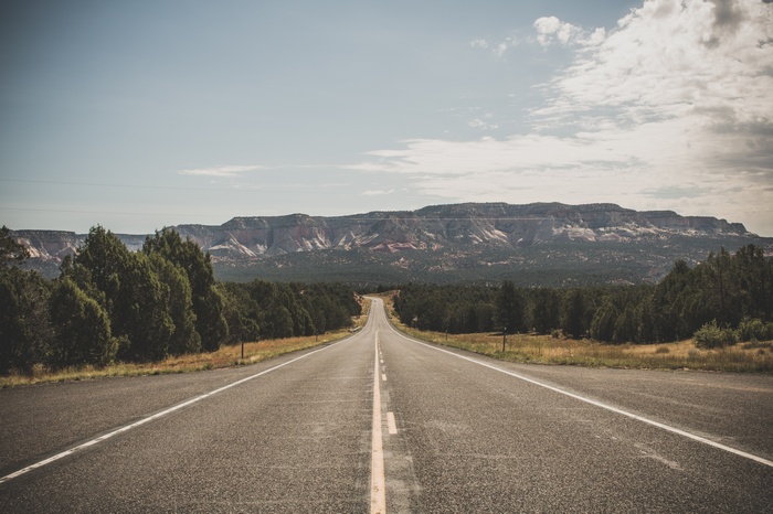 Empty highway leading to distant mountains