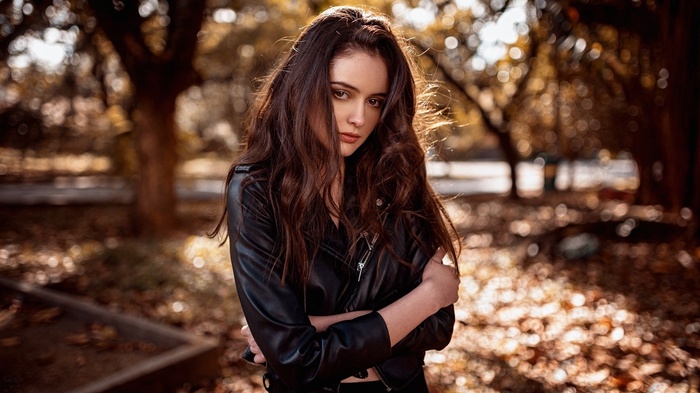 Woman with auburn hair in a leather jacket outdoors