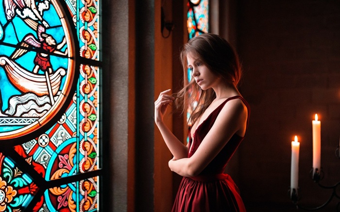 Woman in red dress by stained glass window