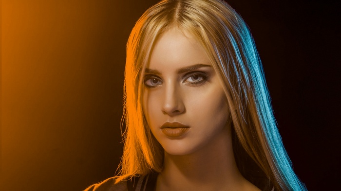 Blonde woman with blue eyes and dramatic lighting