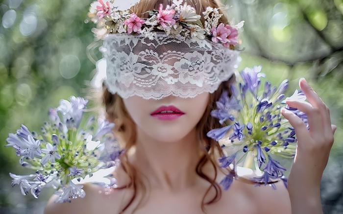 Woman wearing a lace mask and flower crown