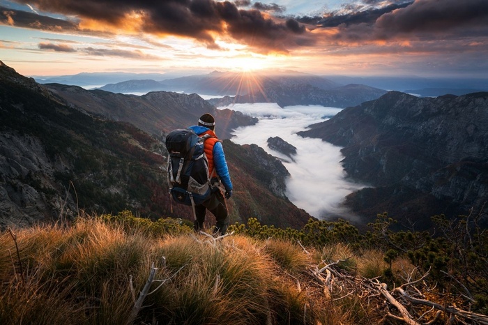 Hiker overlooking misty mountains at sunrise in Bosnia and Herzegovina