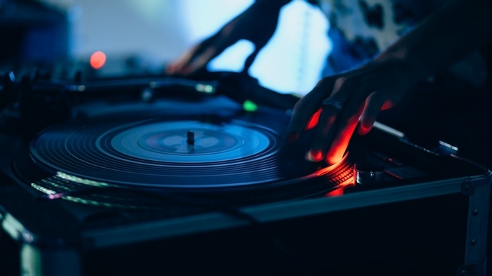 DJ hands on a vinyl record player