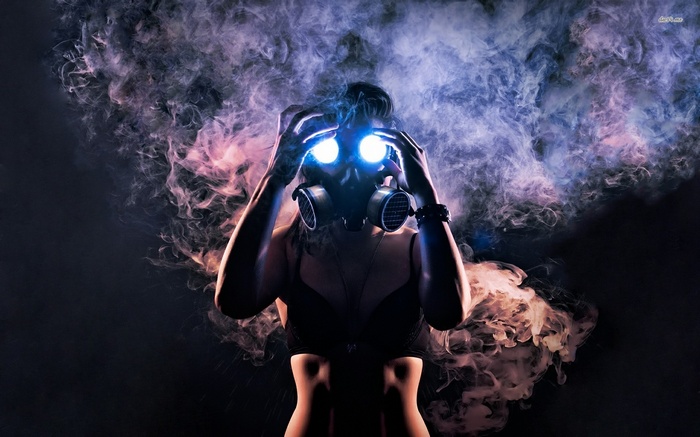 Woman in gas mask with glowing eyes surrounded by smoke